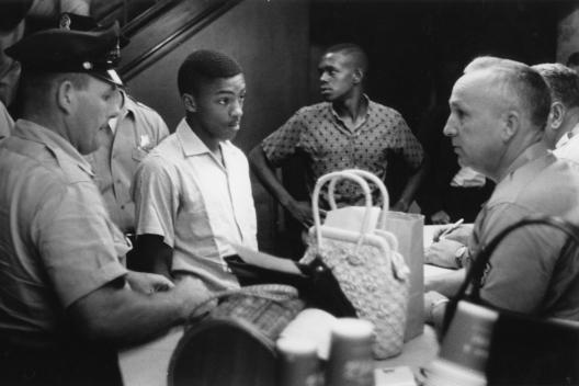 In March and July of 1960, students staged a series of peaceful protests against the segregation of the libraries. In what might be called "read-ins," groups of young African Americans entered the white library and quietly used its resources, perusing shelves of books or sitting at tables reading. Two of these protests resulted in the arrest of the participants on charges of disturbing the peace.  (Image from the James Wilson Photograph Collection, courtesy of the Upcountry History Museum)